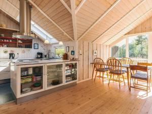 a kitchen and dining room with a table and chairs at 4 star holiday home in Græsted in Græsted +18 photos