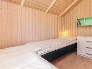 a room with two beds in a wooden wall at 4 star holiday home in Græsted in Græsted