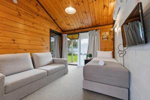 a living room with a couch and a bed at Orewa Motor Lodge in Orewa