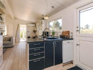 a kitchen with black and white cabinets and a sink at 4 star holiday home in Græsted in Græsted
