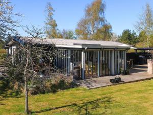 a house with a wooden deck in a yard at 4 star holiday home in Græsted in Græsted