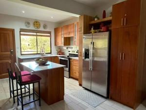 a kitchen with a stainless steel refrigerator and wooden cabinets at Paradizio in Coco