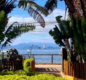 a view of the ocean with a boat in the water at Bouganvile Hostel Ilha Grande in Abraão