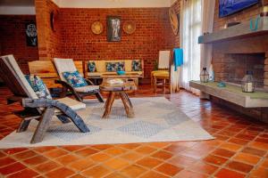 a living room with chairs and a brick wall at Tranquil Hillhouse in Nkoanrua