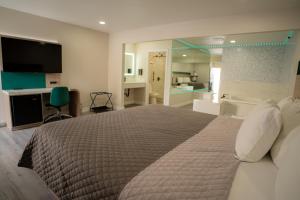 a bedroom with a large bed and a bathroom at Flamingo Motel near Universal Studios in North Hollywood