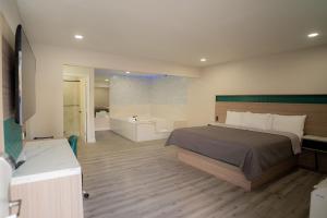 a bedroom with a large bed and a bath room at Flamingo Motel near Universal Studios in North Hollywood +26 photos