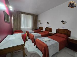 a room with four beds with red covers in it at Hotel Tres Sargentos in Buenos Aires +22 photos