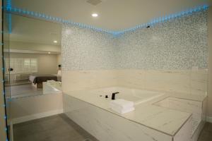 a bathroom with a bath tub with a sink at Flamingo Motel near Universal Studios in North Hollywood