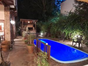a blue swimming pool in a backyard at night at Pamayu Mar de Cobo in Mar de Cobo