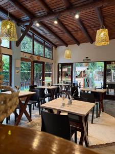 a restaurant with wooden tables and chairs and windows at Pamayu Mar de Cobo in Mar de Cobo