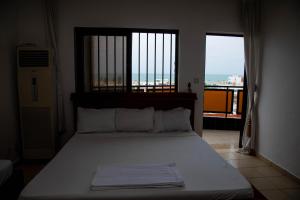 a bedroom with a bed with a view of the ocean at Atlantic Beach Hôtel Bénin in Cotonou +66 photos