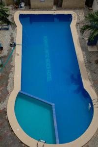 a large blue swimming pool in a yard at Atlantic Beach Hôtel Bénin in Cotonou