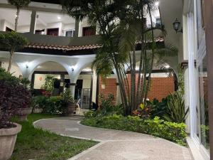 a courtyard of a house with palm trees and a walkway at Portal de José - Hotel Boutique in Ciudad Valles