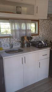 a kitchen with white cabinets and a sink at Veraniega in Playa Hermosa +6 photos