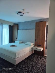 a bedroom with a large white bed with a large headboard at The Bunica Residence in Parila +37 photos