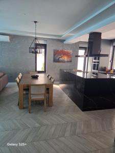 a living room with a table and a kitchen at The Bunica Residence in Parila