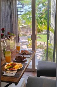 a table with two plates of food and orange juice at Tropical Oasis in San José del Cabo