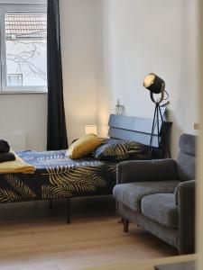 a bedroom with a bed and a couch and a lamp at Les Fontaines in Besançon