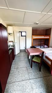 a room with a bed and a table and a kitchen at Šiška Kemp in Doksy