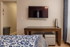 a bedroom with a desk and a tv on the wall at Spacious King Historic Art Deco Studio in Anchorage