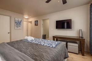 a bedroom with a bed and a desk and a television at Spacious King Historic Art Deco Studio in Anchorage +12 photos