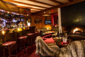 - un bar avec des chaises et une cheminée dans la pièce dans l'établissement Hôtel du Bourg, à Valmorel