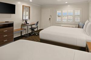a hotel room with a bed and a desk at El Castell Motel in Monterey +53 photos