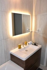 a bathroom with a white sink and a mirror at Magic House- London in Plumstead +34 photos