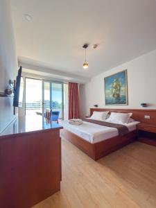a bedroom with a bed with a desk and a window at Hotel Porto A in Ulcinj