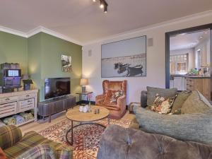 a living room with a couch and a tv at Rosselaer in Balen