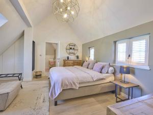 a bedroom with a large bed and a chandelier at Rosselaer in Balen +82 photos