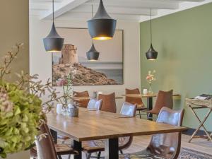 a dining room with a wooden table and chairs at Rosselaer in Balen