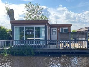 a small house on a dock on a body of water at Sluisje 55 in Kuinre