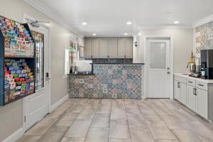 a kitchen with white cabinets and a tile floor at El Castell Motel in Monterey