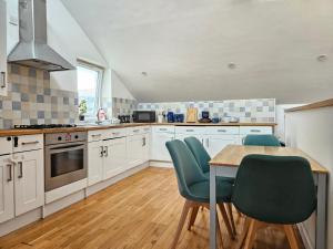 a kitchen with white cabinets and a table and chairs at Flat In City Centre in Cambridge