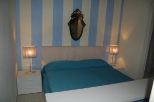 a bedroom with a bed with blue and white stripes at Sonomusica B&B in Gazzola Di Rivalta +10 photos