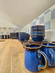 a group of blue cups sitting on top of a kitchen counter at Flat In City Centre in Cambridge