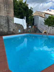 a large blue swimming pool next to a building at Casa dos Cândidos in Alagoa +11 photos