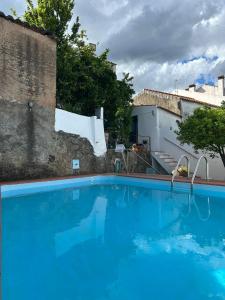 a large blue swimming pool next to a building at Casa dos Cândidos in Alagoa