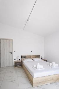 two beds in a bedroom with white walls at Domus Villa in Ermioni +69 photos