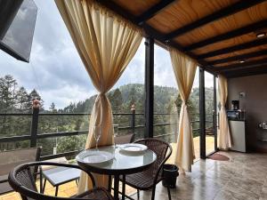 a dining room with a table and chairs on a balcony at Meraki Cabañas & Glamping By GEstores in Mineral del Chico