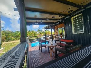 a deck with benches and a table on a house at Bungalow Sugarcane in Saint-Louis