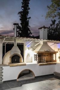 an outdoor pizza oven on top of a patio at Domus Villa in Ermioni