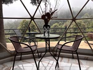 a table and chairs in front of a window at Meraki Cabañas & Glamping By GEstores in Mineral del Chico