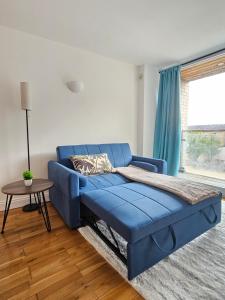 a blue couch in a living room with a table at Flat In City Centre in Cambridge