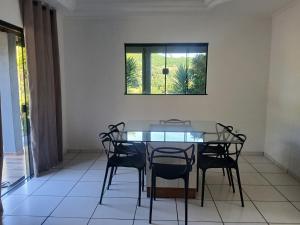 a dining room with a table and chairs and a window at Chácara bela vista in Socorro
