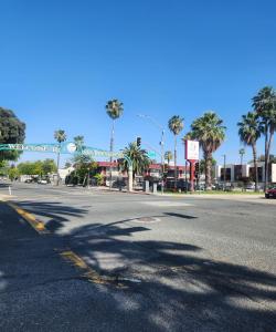 an empty street with palm trees and a building at SimpleStay Suites - Downtown San Bernardino in San Bernardino