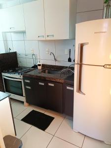 a kitchen with a white refrigerator and a sink at Ap Completo na zona Nobre com 3 quartos, sendo 1 suíte in Teresina