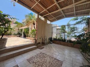 an outdoor patio with a porch and a fence at Casa las Palmas in Acapulco