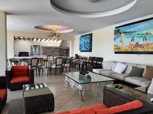 a living room with a couch and a dining room at Casa las Palmas in Acapulco